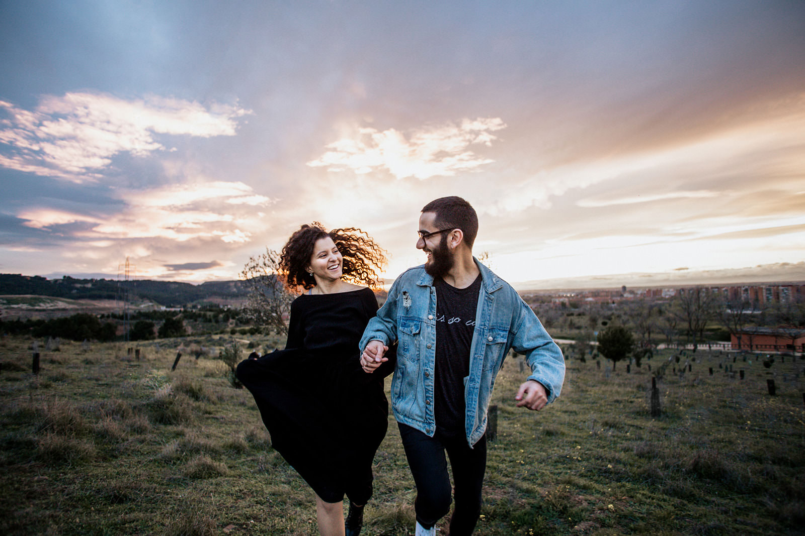 pareja de novios corriendo con el atardecer de fondo