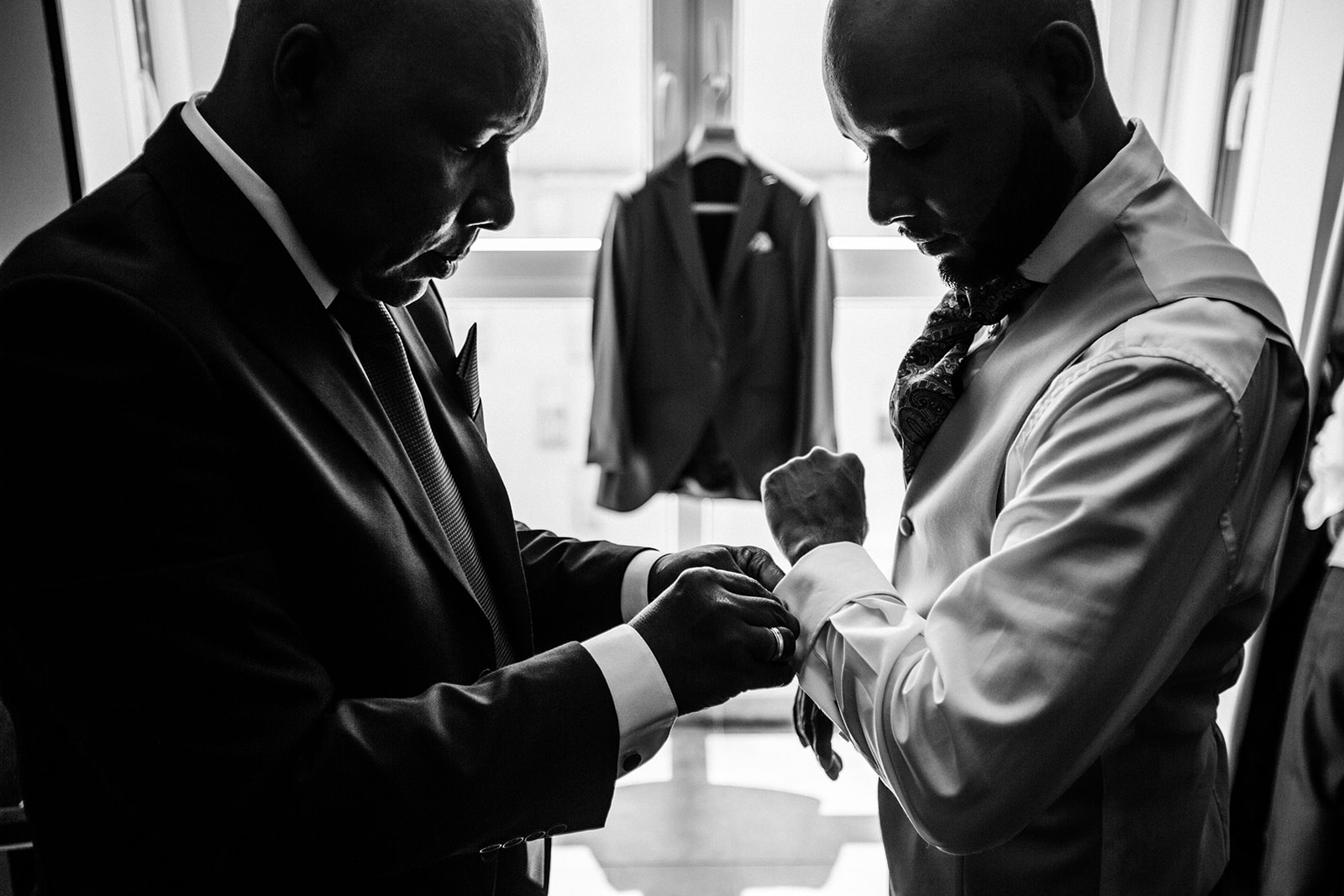 Padre ayudando a su hijo a vestir para la boda