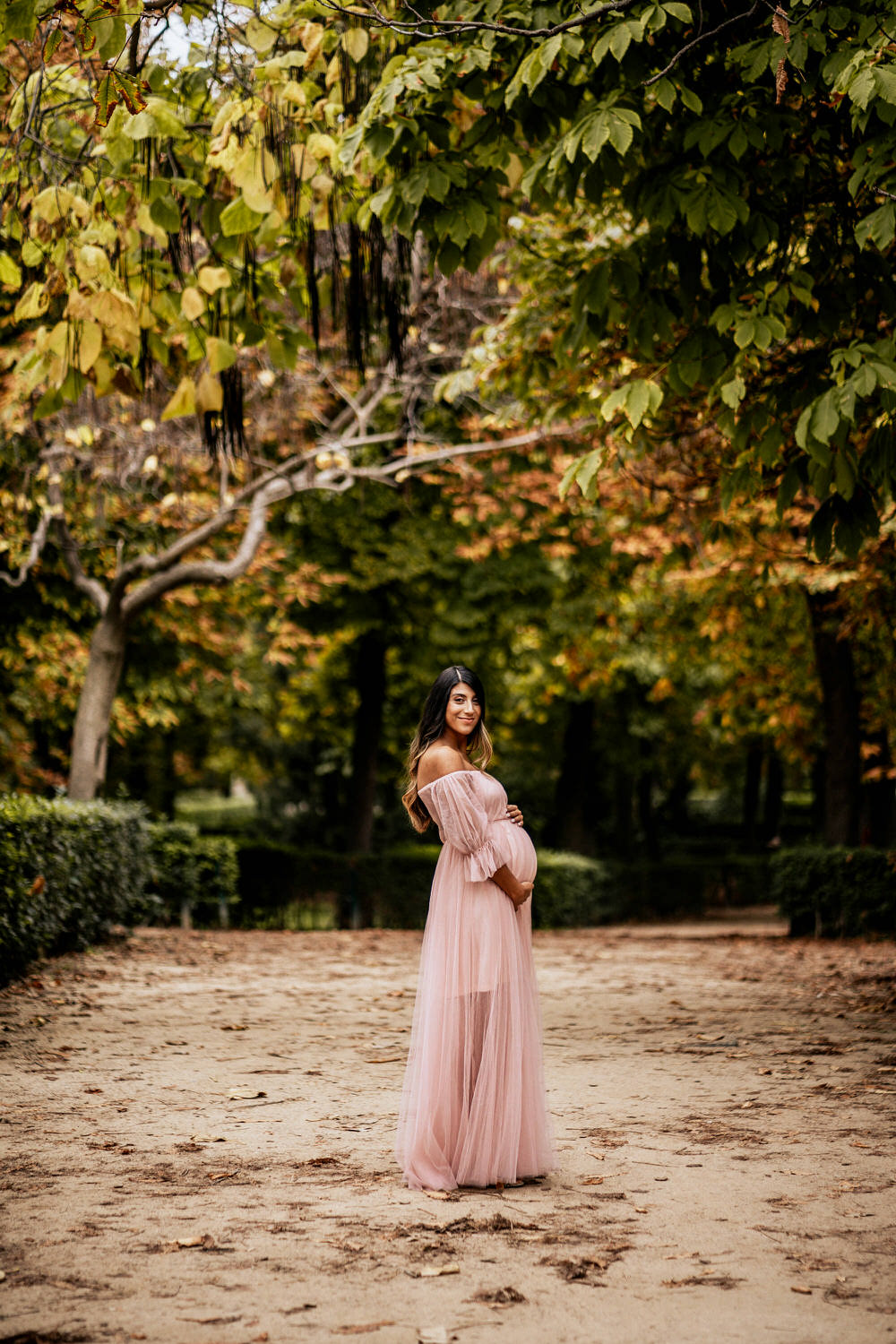 mujer embarazada en el parque con vestido rosa
