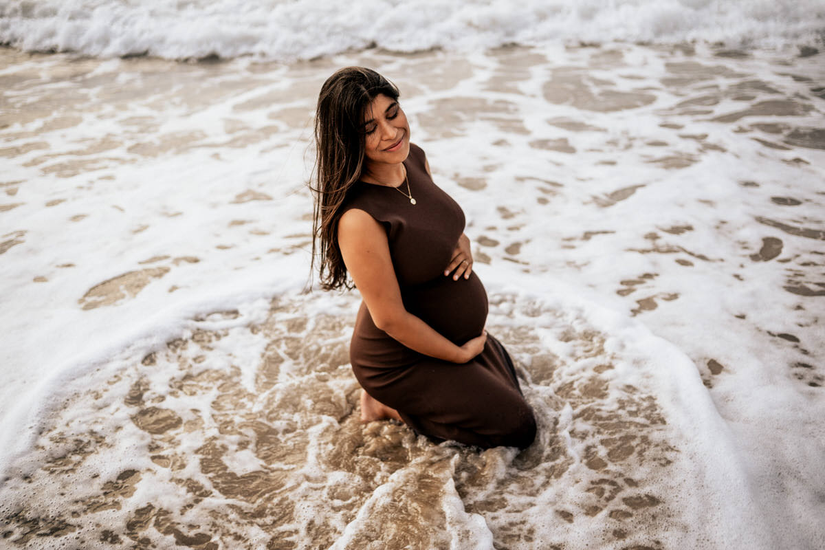 embarazada sentada a orillas del mar