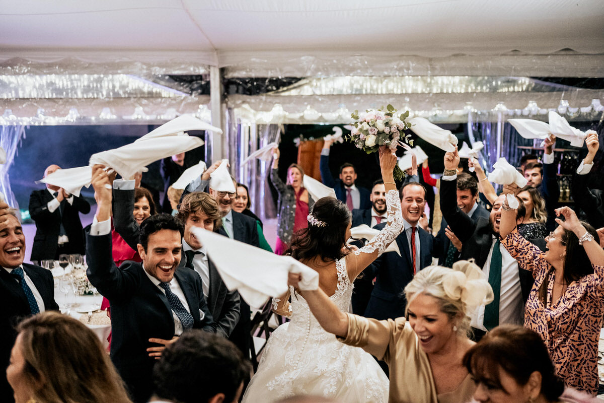 invitados celebrando la entrada de los novios con los pañuelos arriba