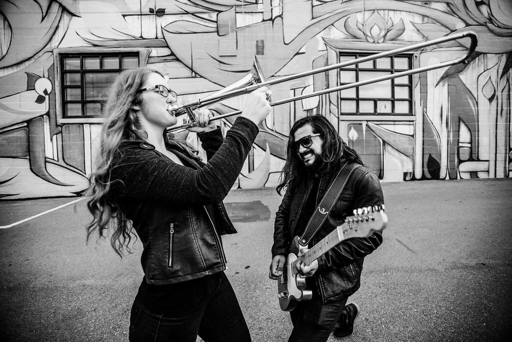 musicians couple holding a trumpet and guitar musicians couple holding a trumpet and guitar