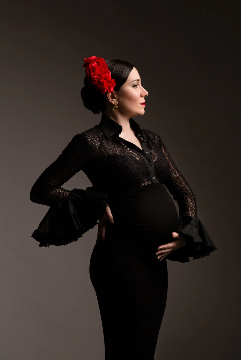 embarazada flamenco en estudio vestido negro con adorno rojo en la cabeza