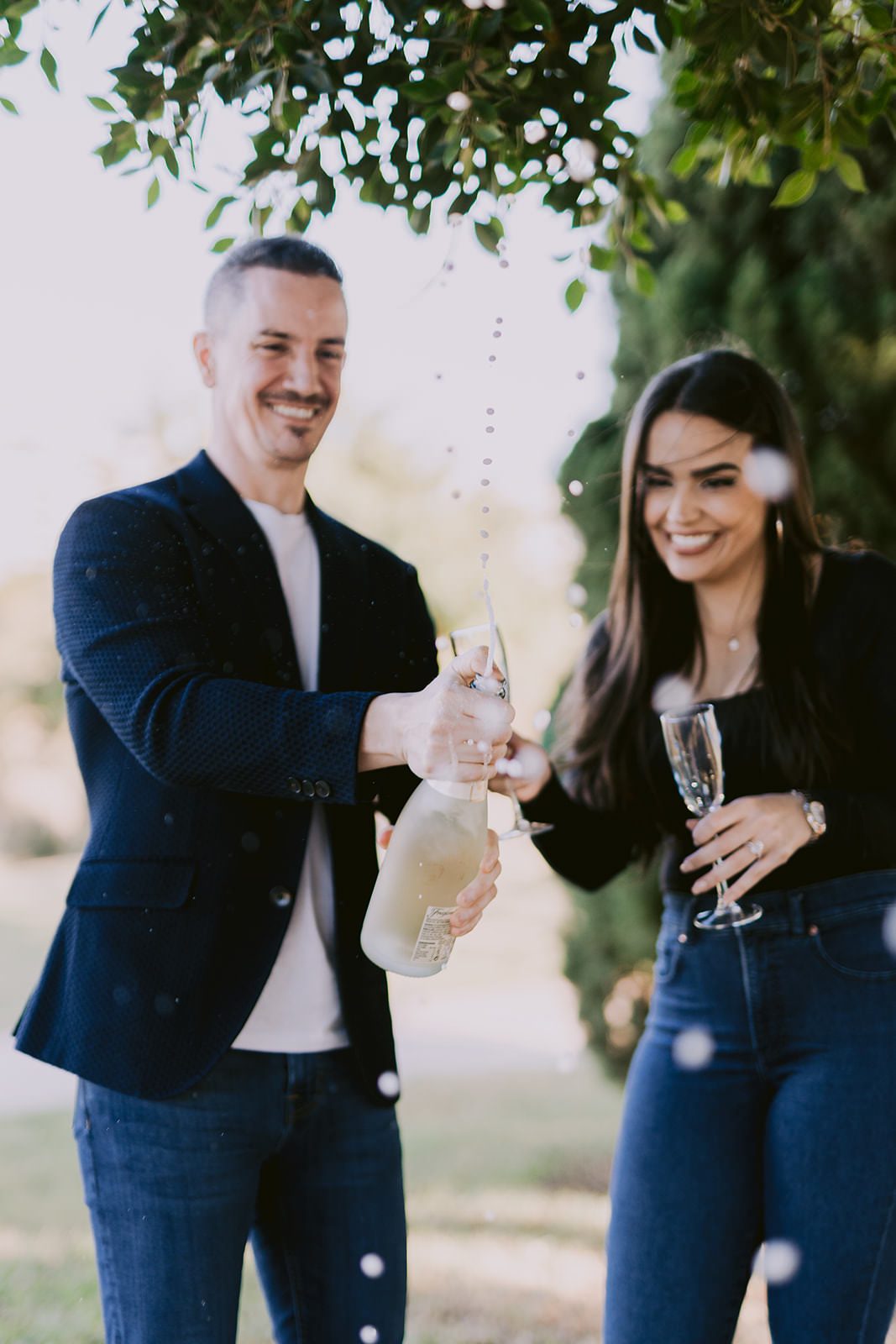 couple celebrating engagement with champagne