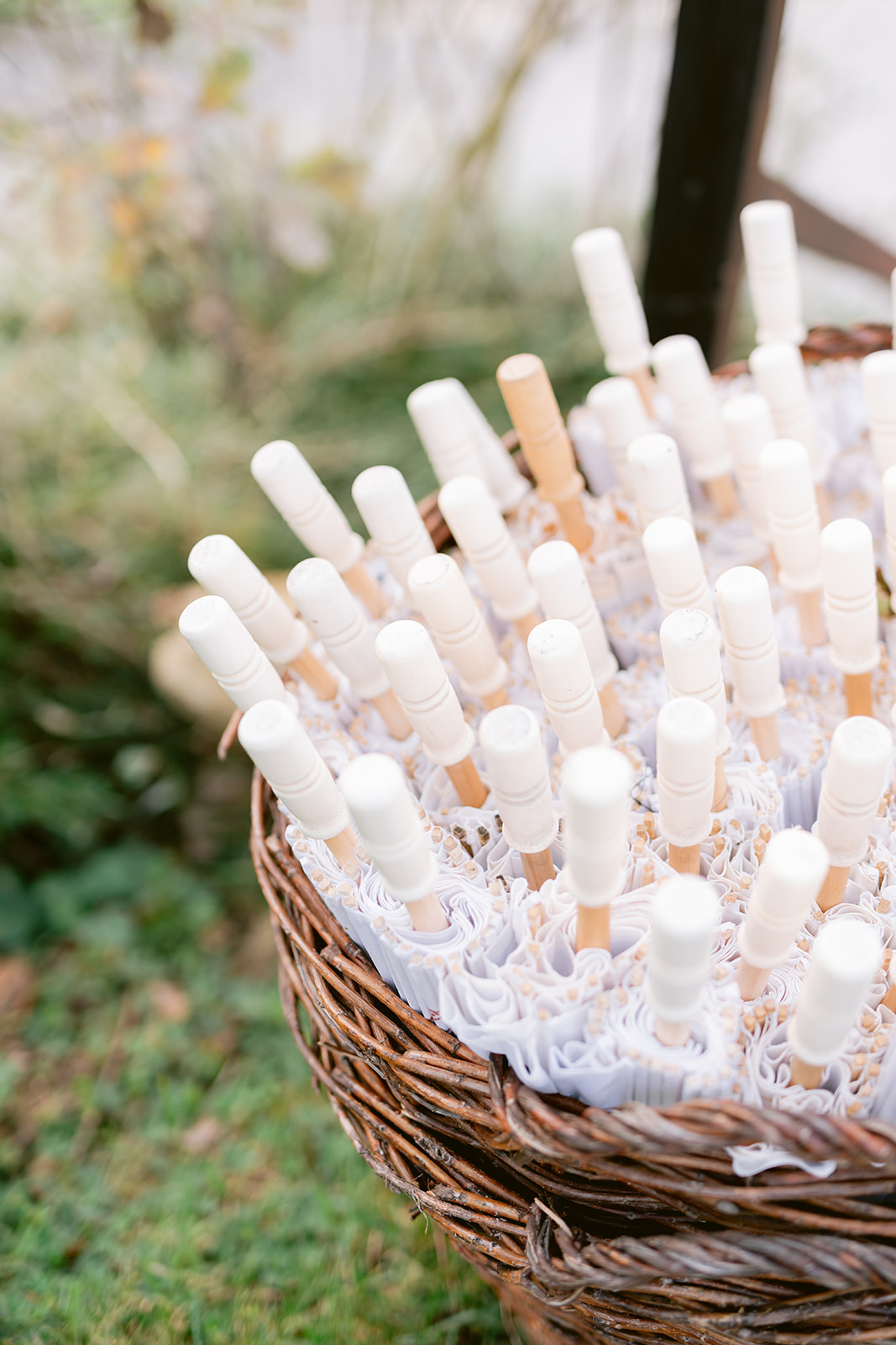 Artistic detail of transparent umbrellas displayed in a rustic basket, part of thoughtful vineyard wedding décor