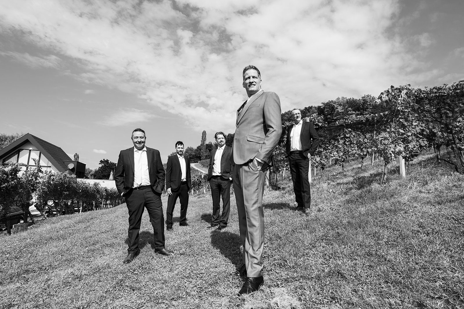 Groom standing confidently among vineyard rows during his wedding day at Weingut Holler in Austria